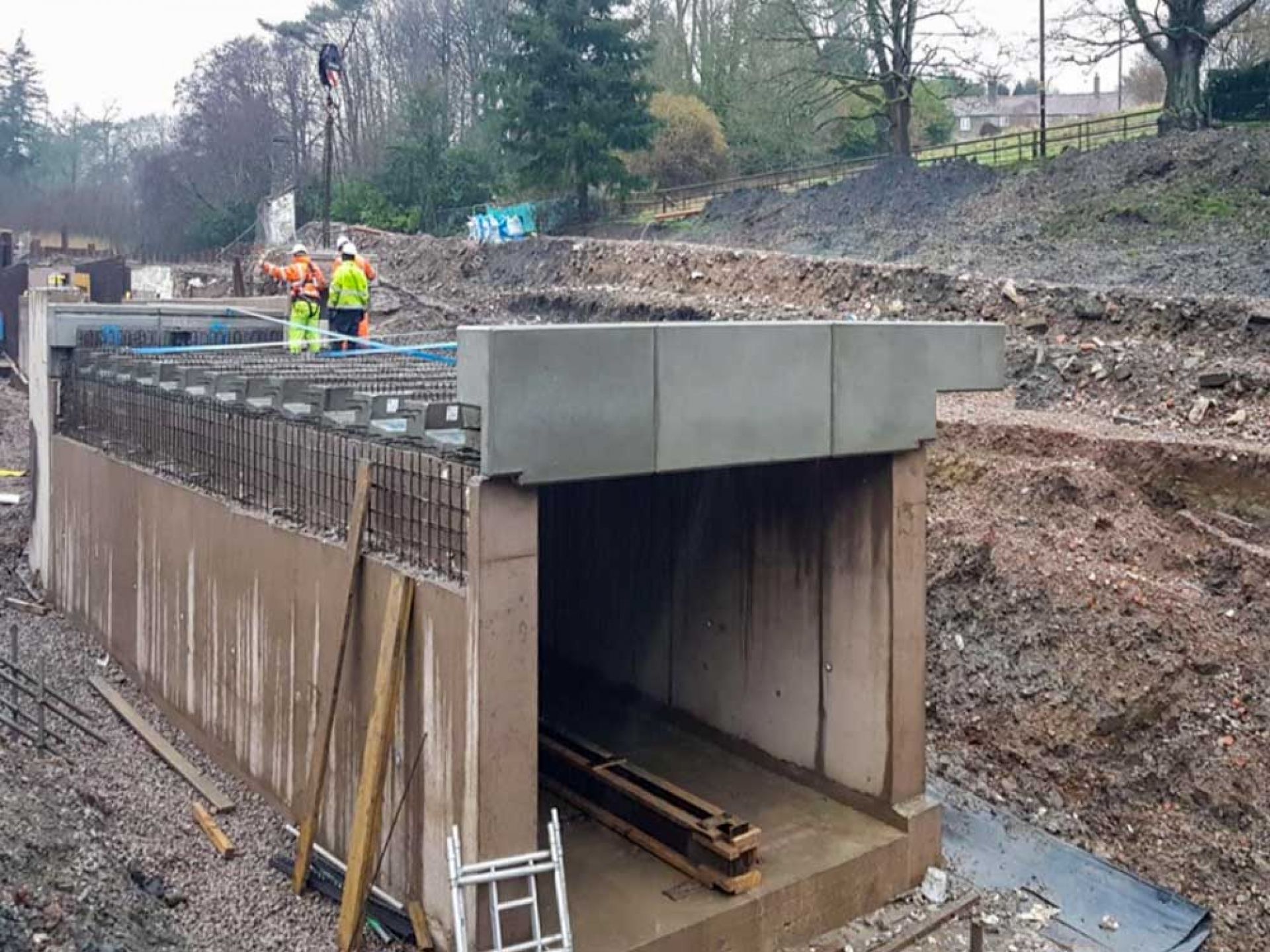 Construction workers on top of large concrete bridge development.