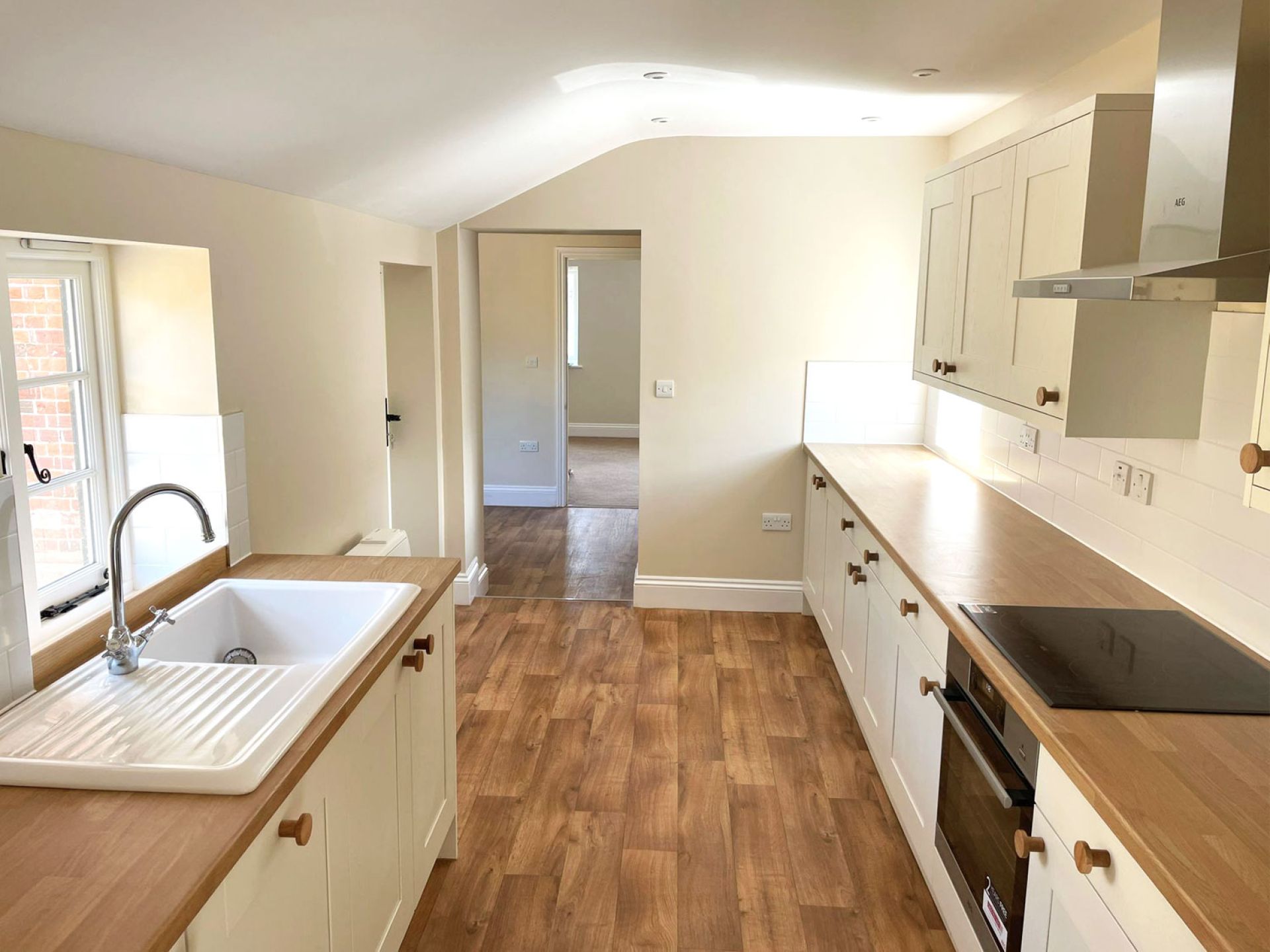 Brand new kitchen fitted in cranborne house refurbishment with magnolia walls, white ceiling and wooden floor details.