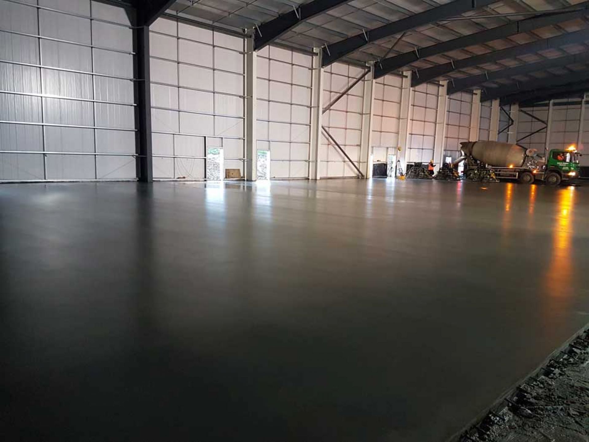 Inside large uk warehouse construction with cement mixer in background.