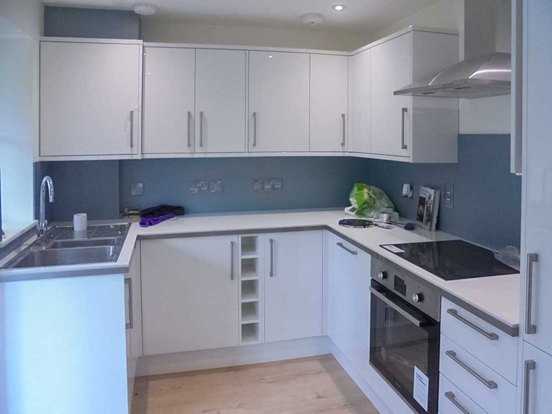 New kitchen area completed with grey blue walls and white units.