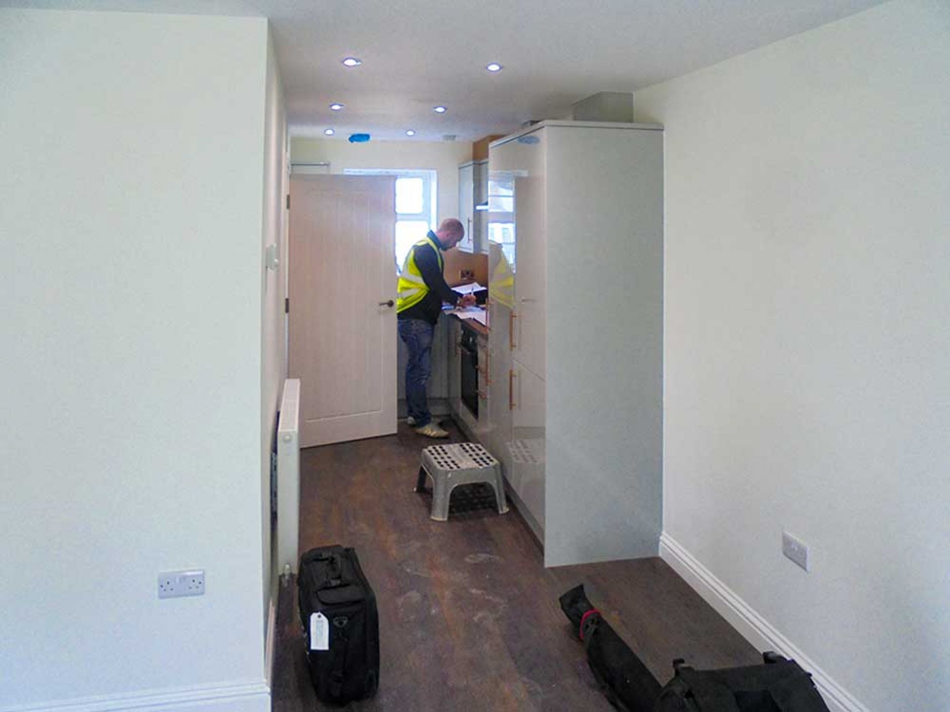 Construction making notes in new kitchen area of housing development.