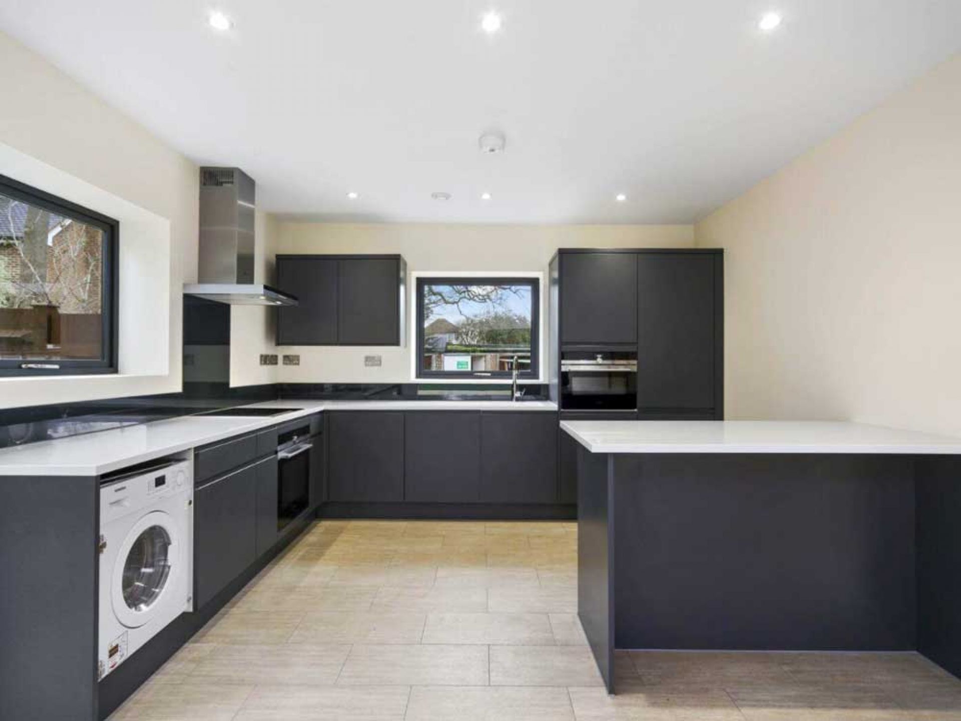 New house construction kitchen area with washing appliances and darl grey colour scheme.