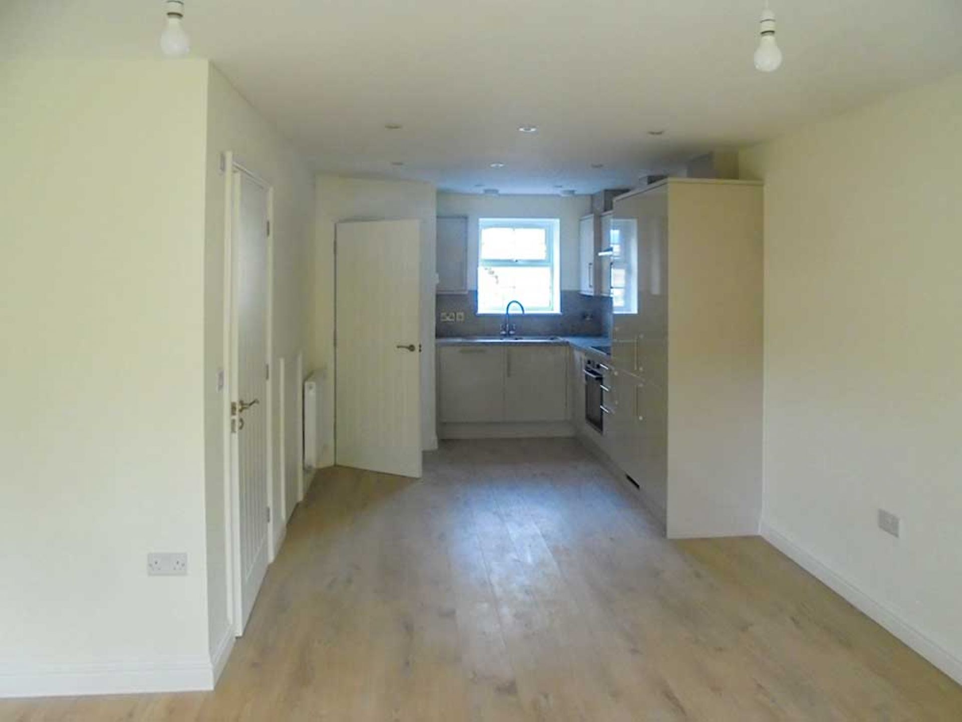 Completed downstairs living area looking from one end to the kitchen area.