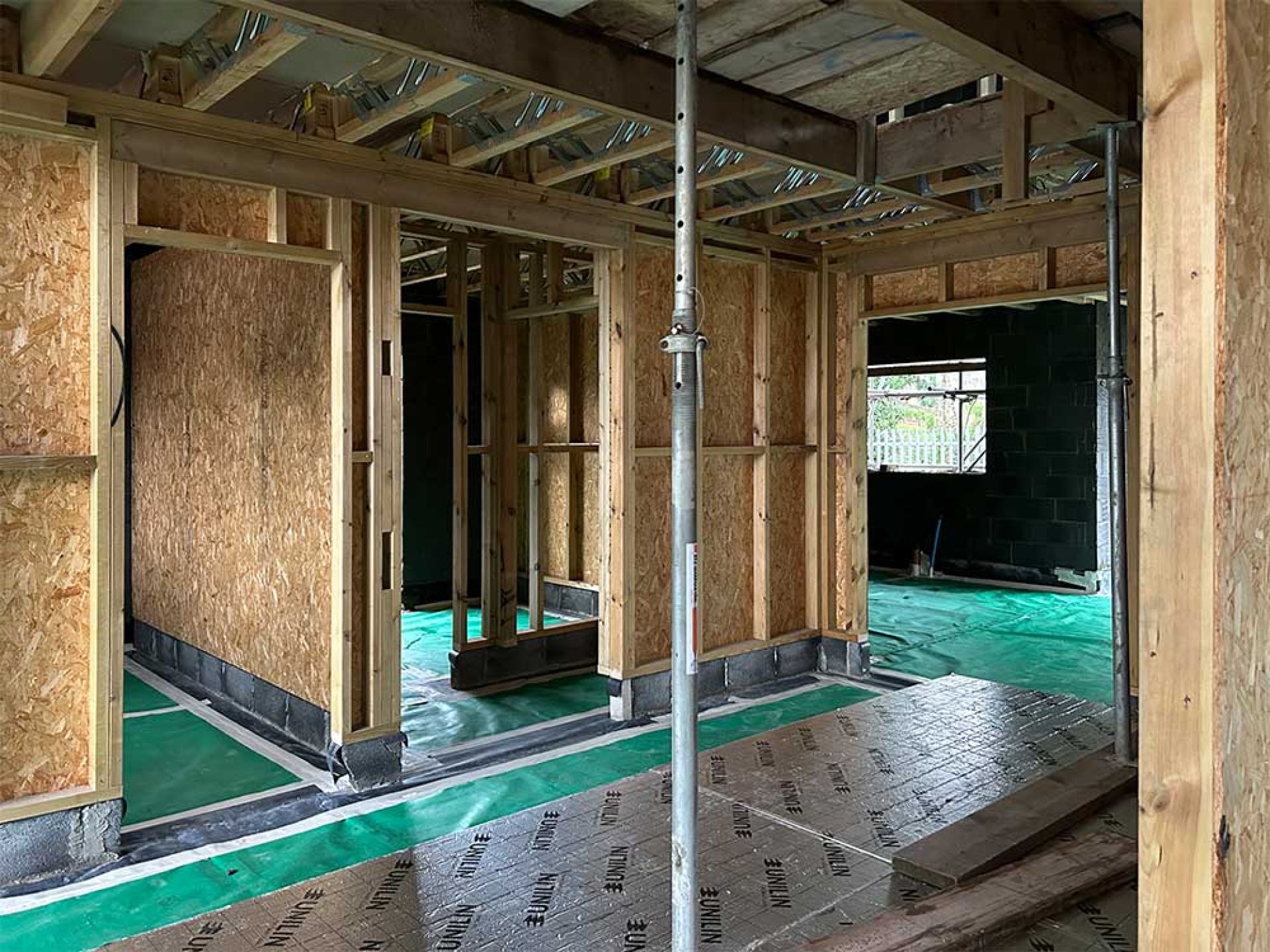 Internal construction of five bedroom manor house with wooden walls and scaffolding.