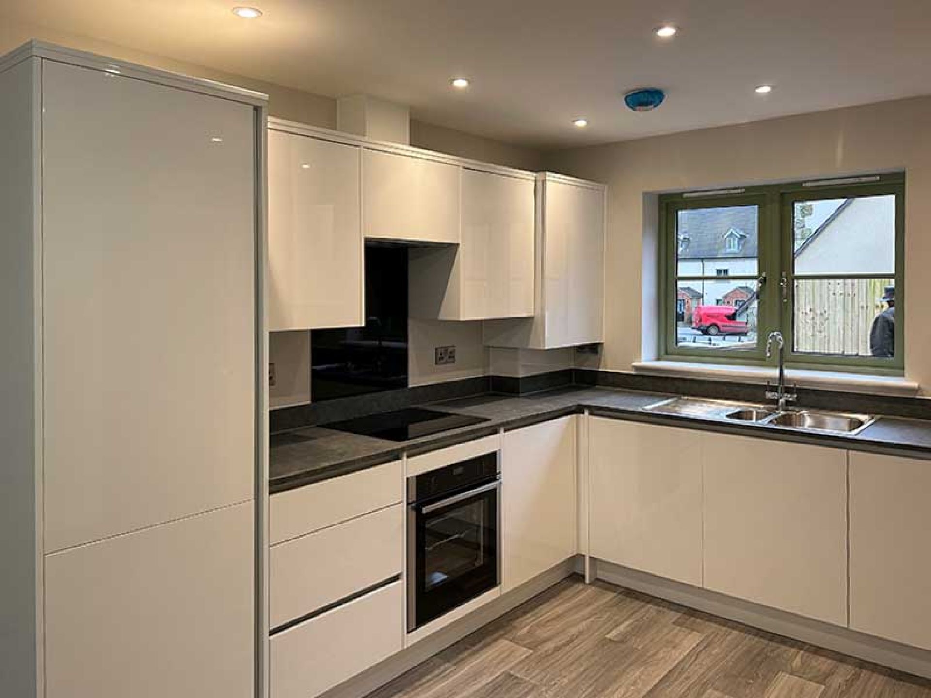 View of the kitchen are at one of the terraced houses in the bourton mill site home looking at the sink area and fridge.