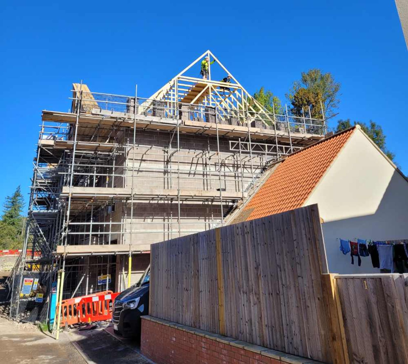 Side view of 5 townhouse with roof truss fitted and scaffolding on exterior.