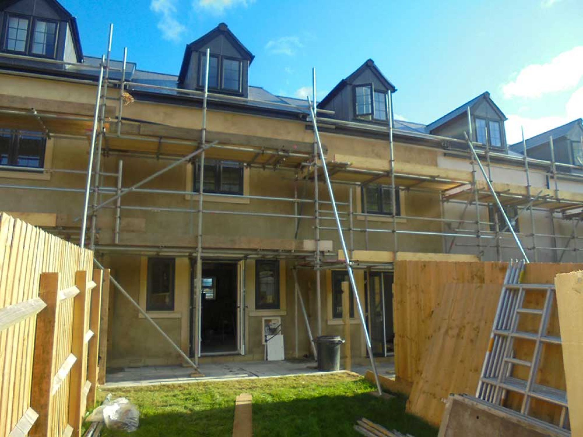 Row of houses during development with scaffolding outside.