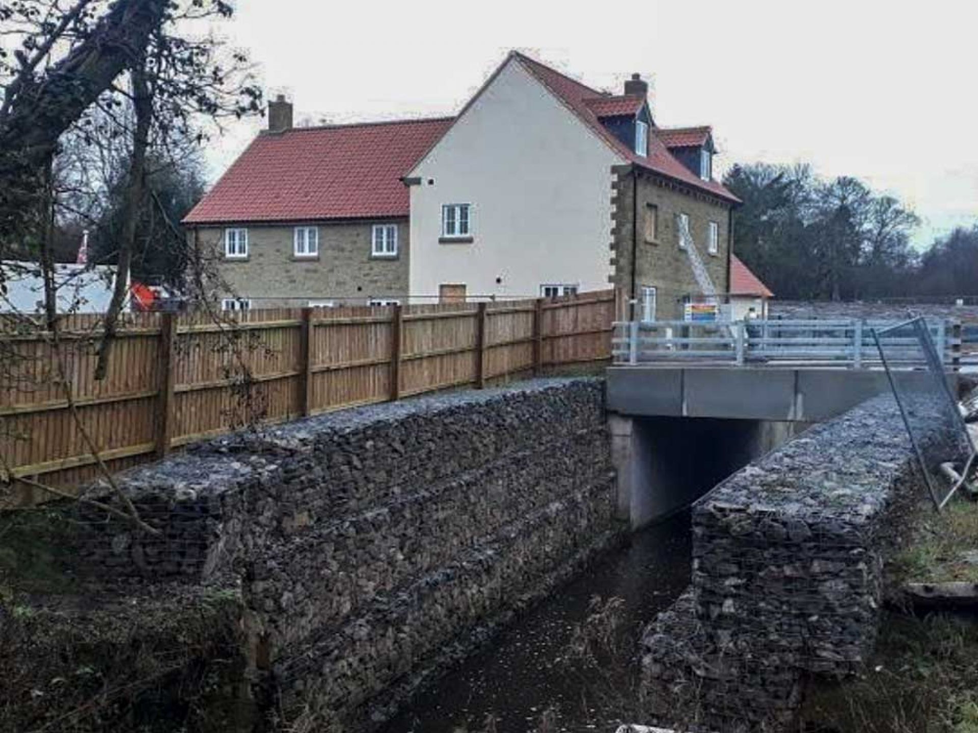 Completed road bridge construction with new houses in background.