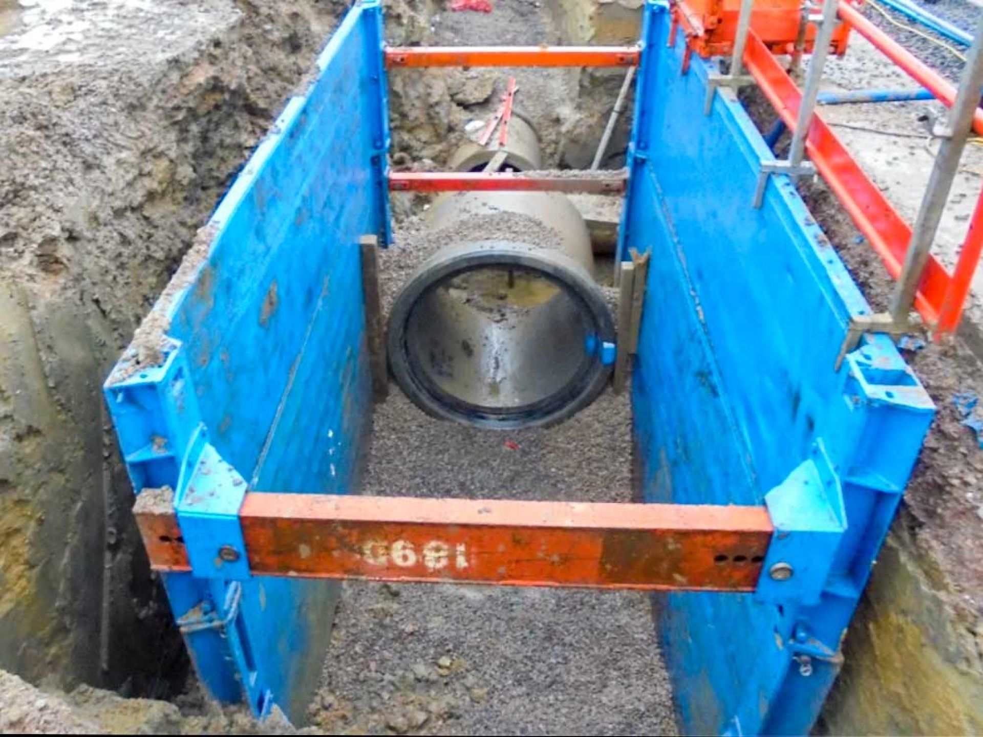 Large circular piece of concrete being lowered into the ground.