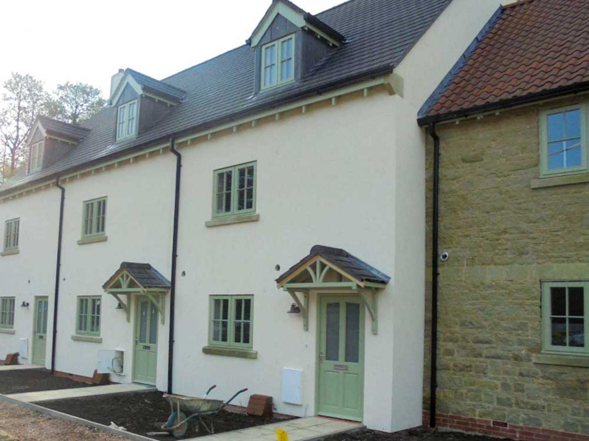 Close up of white houses with green doors in new housing development.